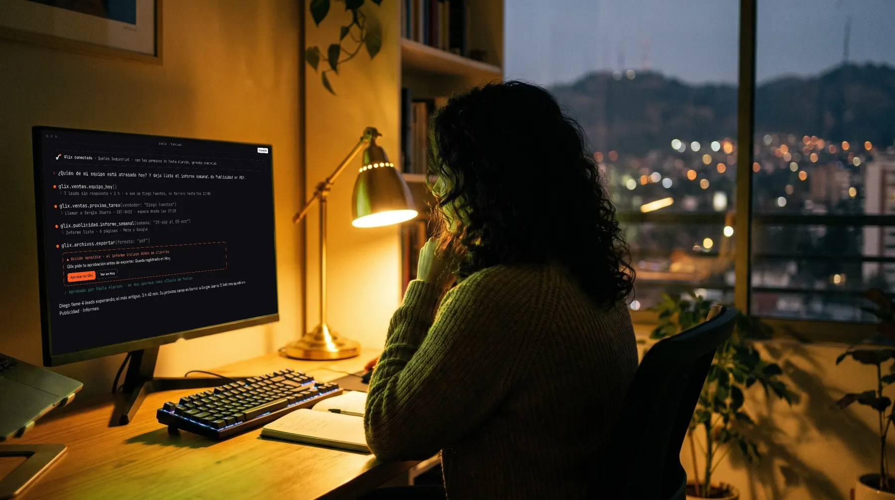 De noche, en el escritorio de su casa, una gerenta trabaja con Glix desde Claude Code en un monitor grande.